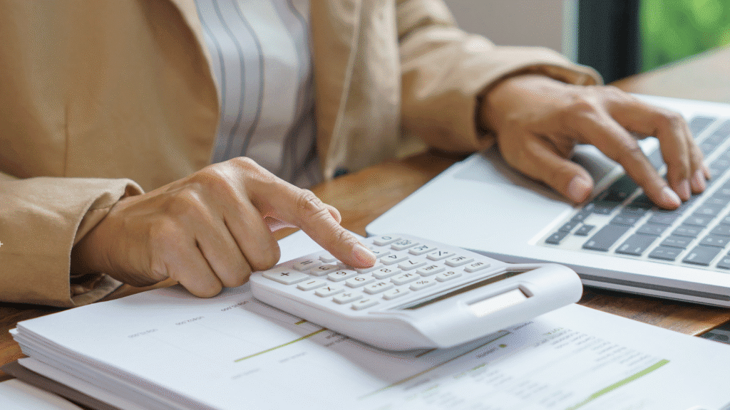 Person sitting at a desk with a laptop and a calculator